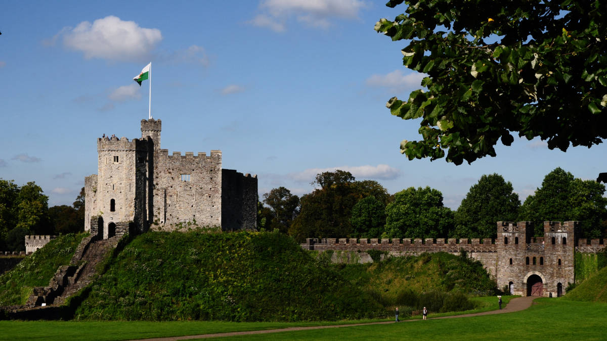 Fortified battlements of Cardiff Castle upon grassy hill